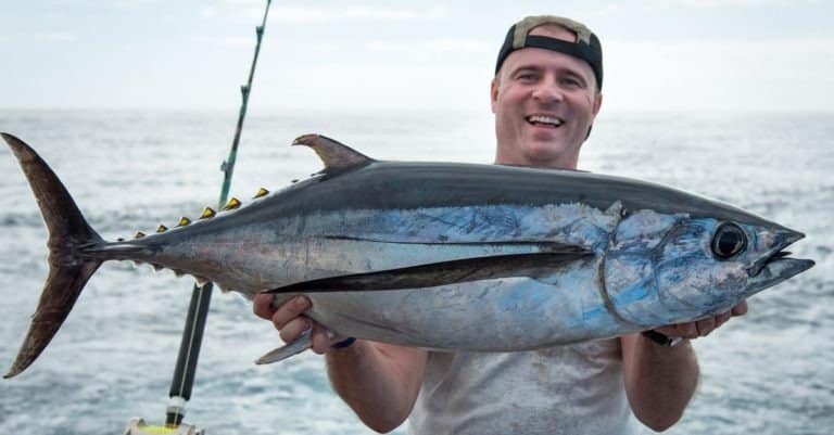 Happy angler holding big tuna fish