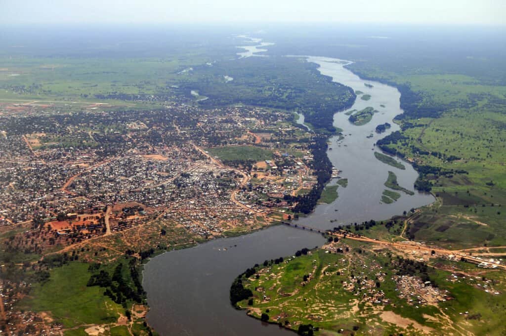 Trên không của Juba, thủ đô của Nam Sudan, với dòng sông Nile chảy ở giữa.  Trung tâm thành phố Juba ở phía trên trung tâm gần sông, và sân bay có thể được nhìn thấy ở phía trên bên trái.  Hình từ nam ra bắc.