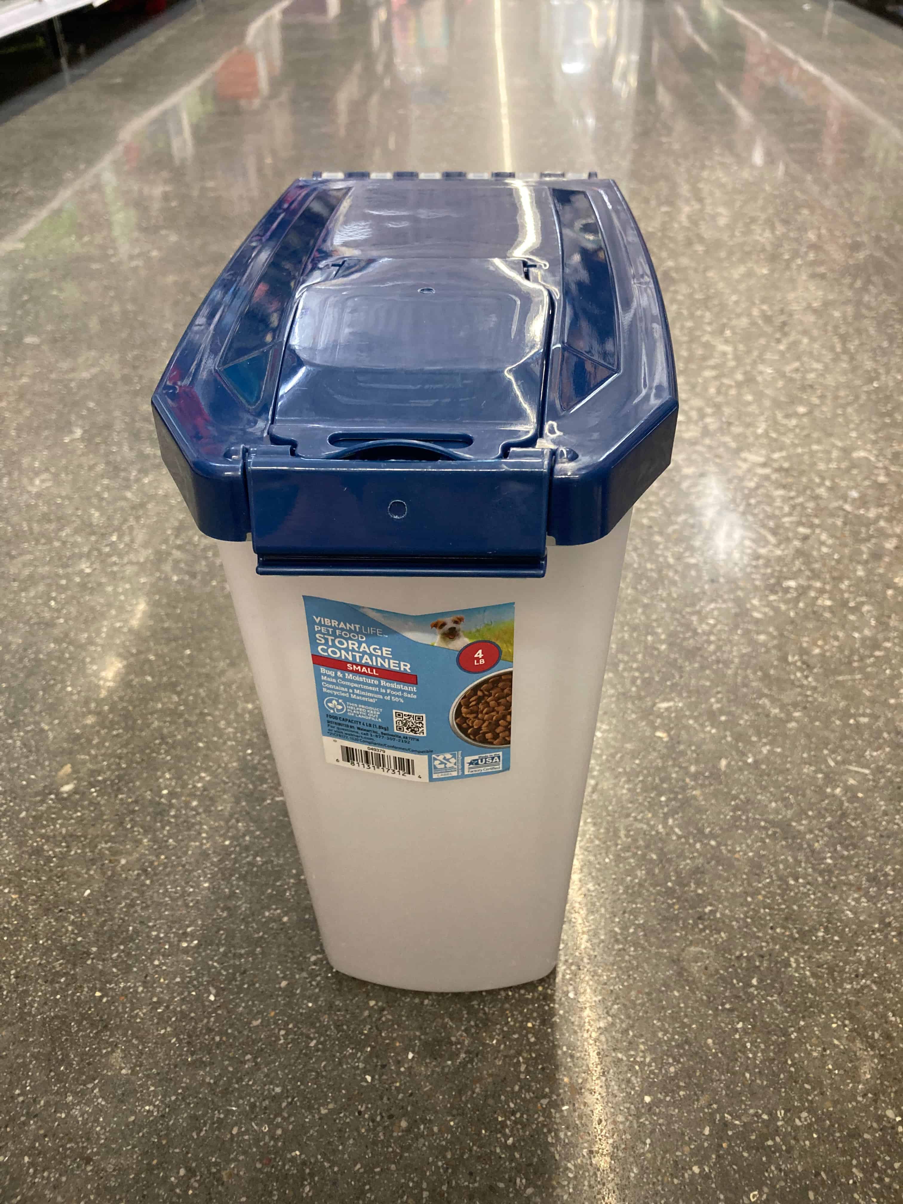 A Vibrant Life brand pet food container sits on a floor.