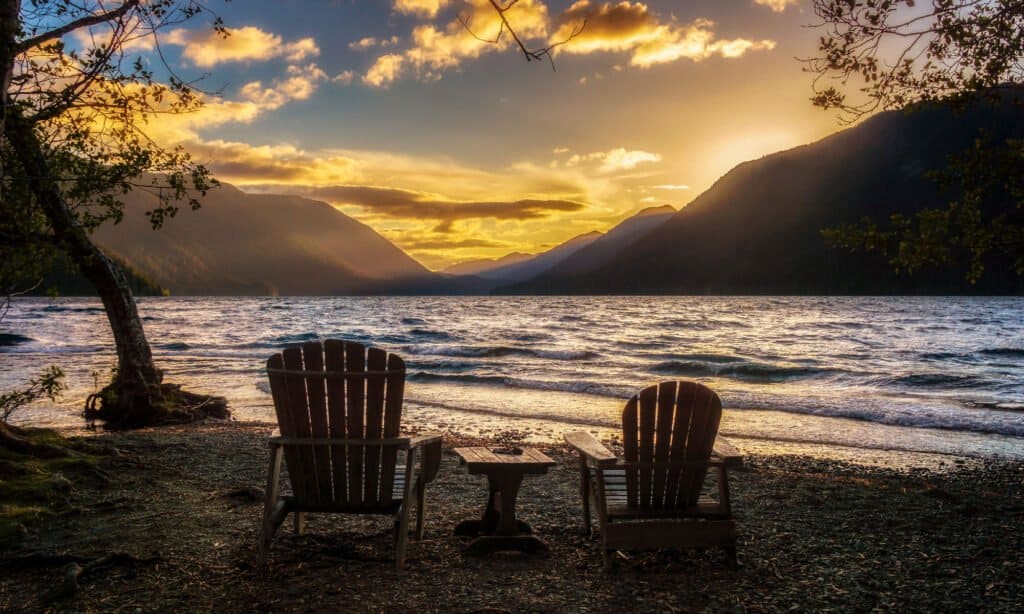 Lake Crescent and two chairs on the shore. 