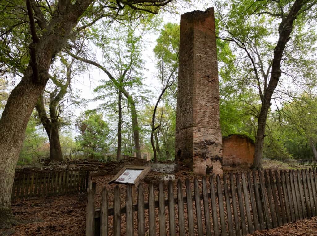 A historic sugar mill remains in ruins at Fontainebleau State Park near Mandeville, Louisiana, with the brick chimney and partial brick walls still standing from the 19th-century facility.
