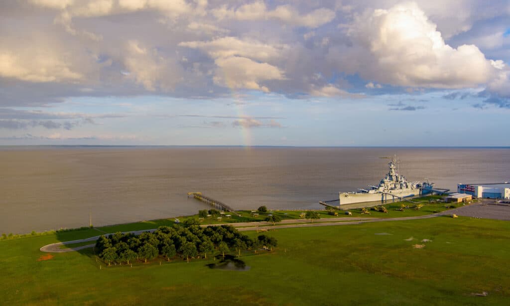A rainbow over the USS Alabama battleship at sunset sunset