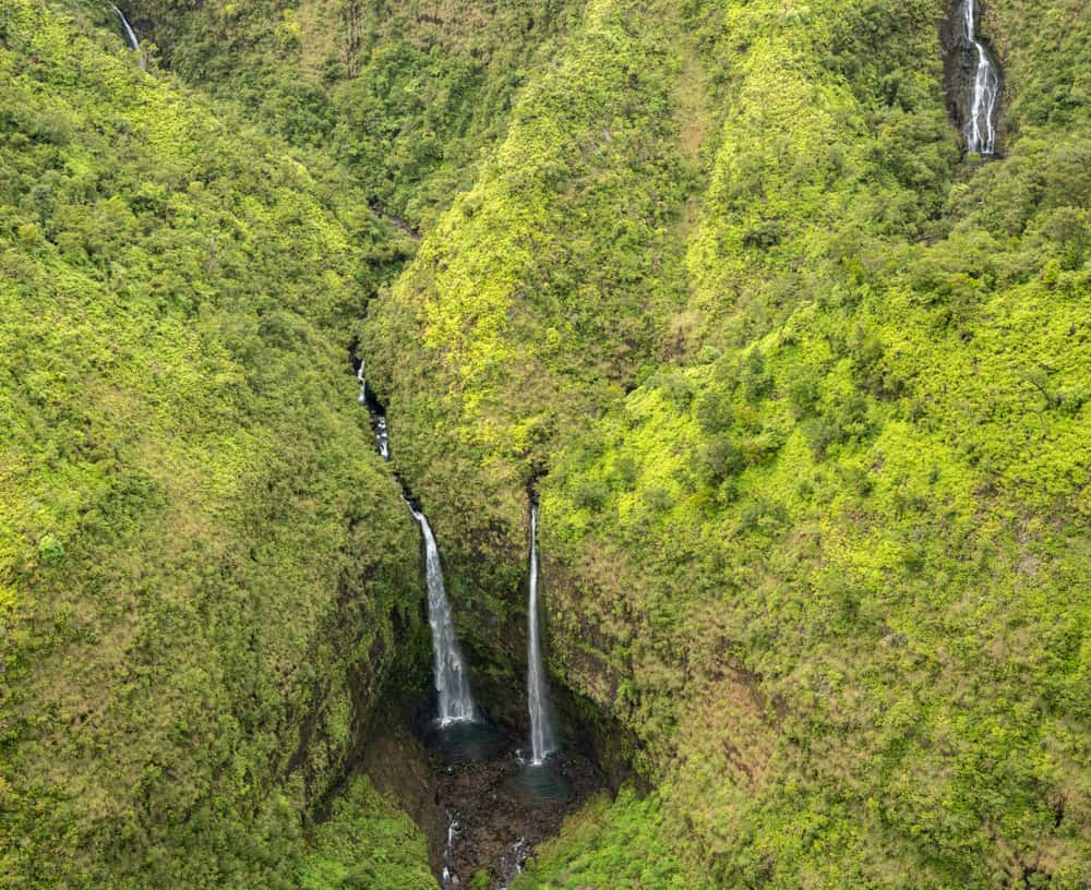 Aerial view of waterfalls in crater of Mount Waialeale on hawaiian island of Kauai from helicopter flight
