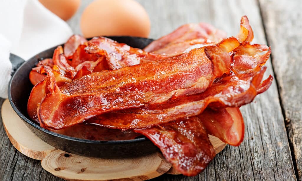 A plate of bacon overflowing in a skillet