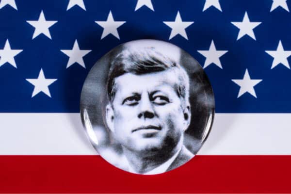 A John F. Kennedy badge pictured over the USA Flag