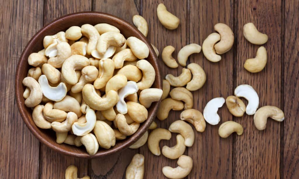 Overflowing bowl of halved cashew nuts