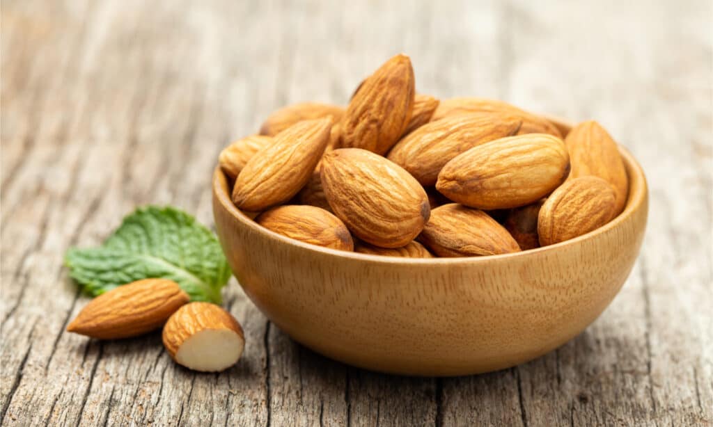 Almonds in Wooden bowl on old wooden table