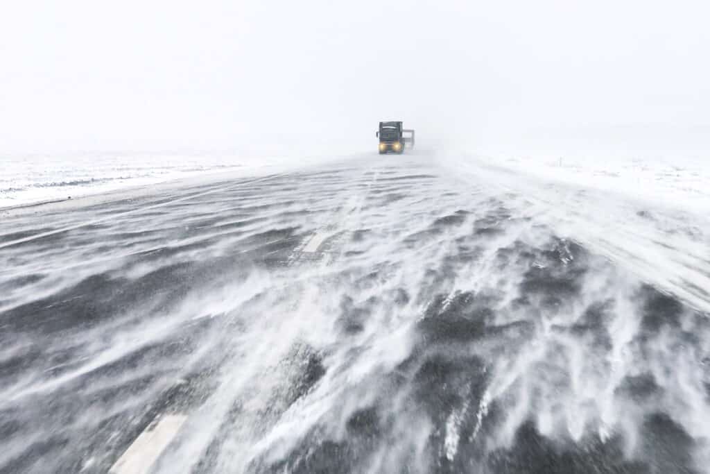 snow blizzard on the highway with truck