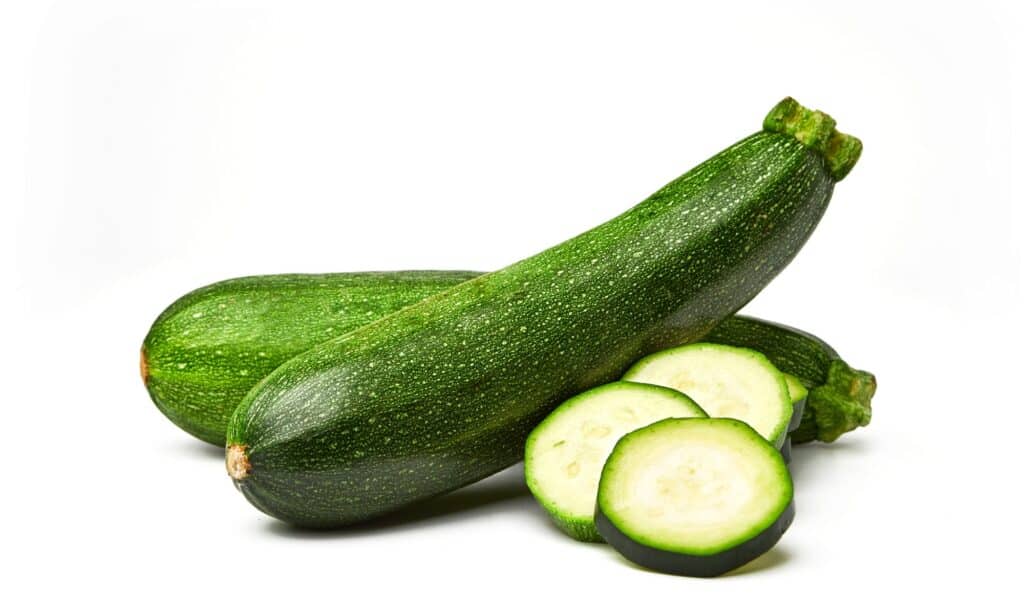 fresh-whole-and-sliced-zucchini-isolated-on-white-background-from-top-picture-id1149201983