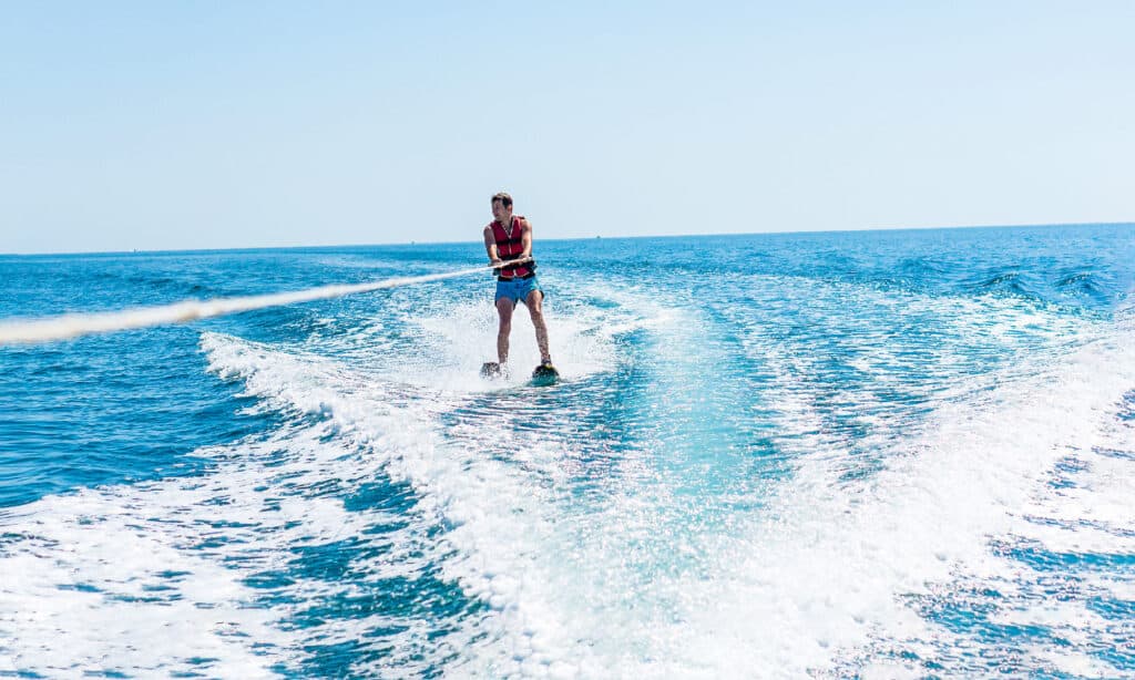 Young man glides on water skiing