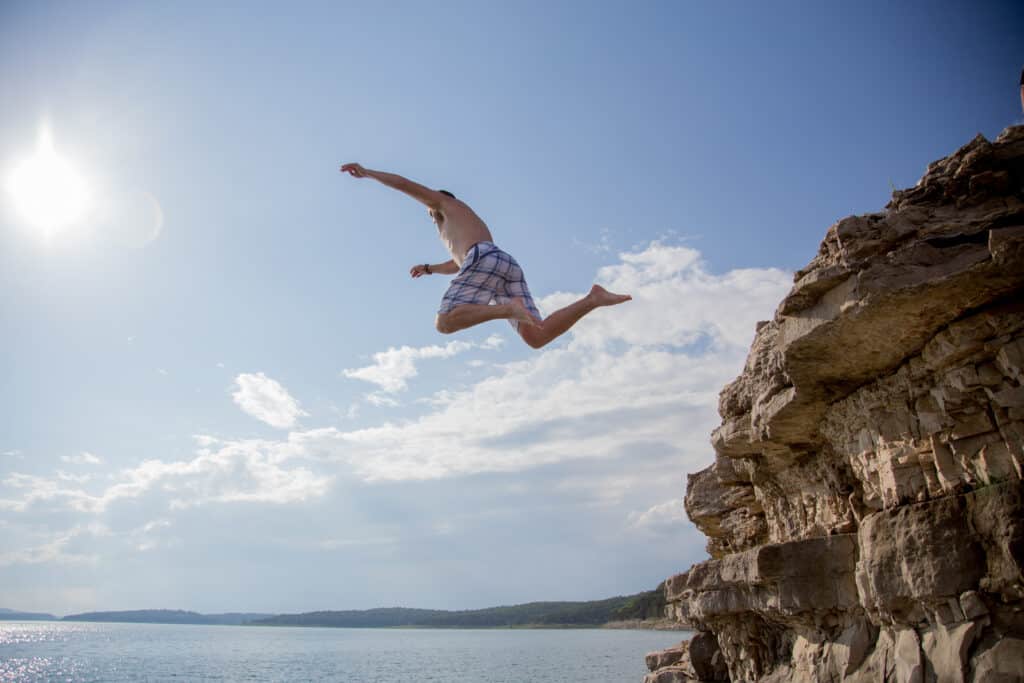 man jumping from cliff