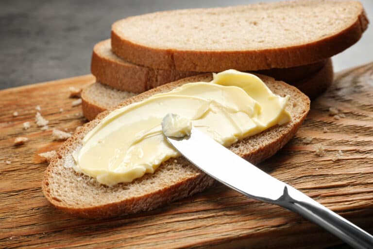 Knife spreading butter on toast