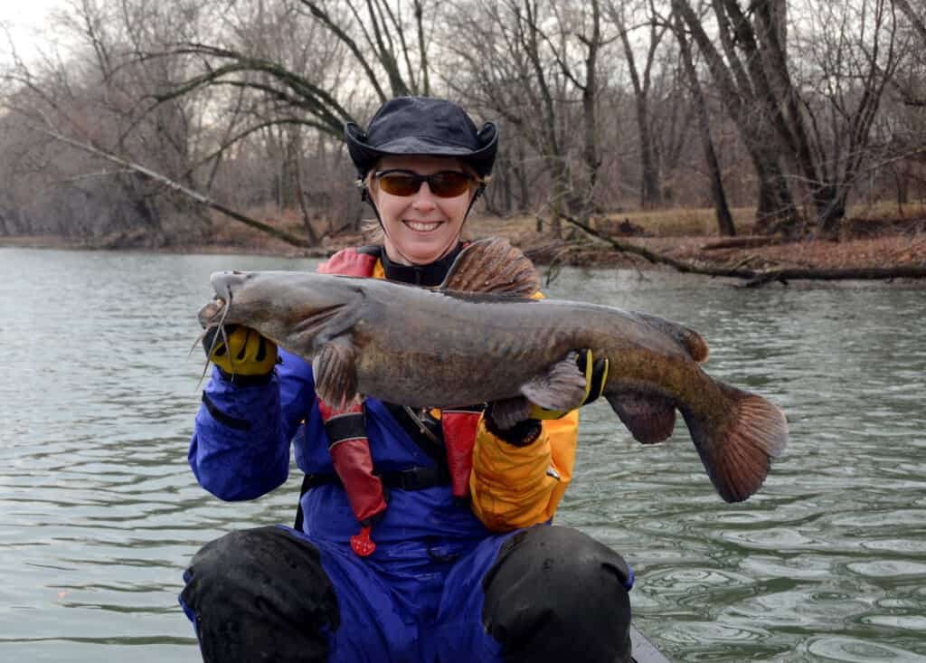 A woman proudly holding a Flathead catfish