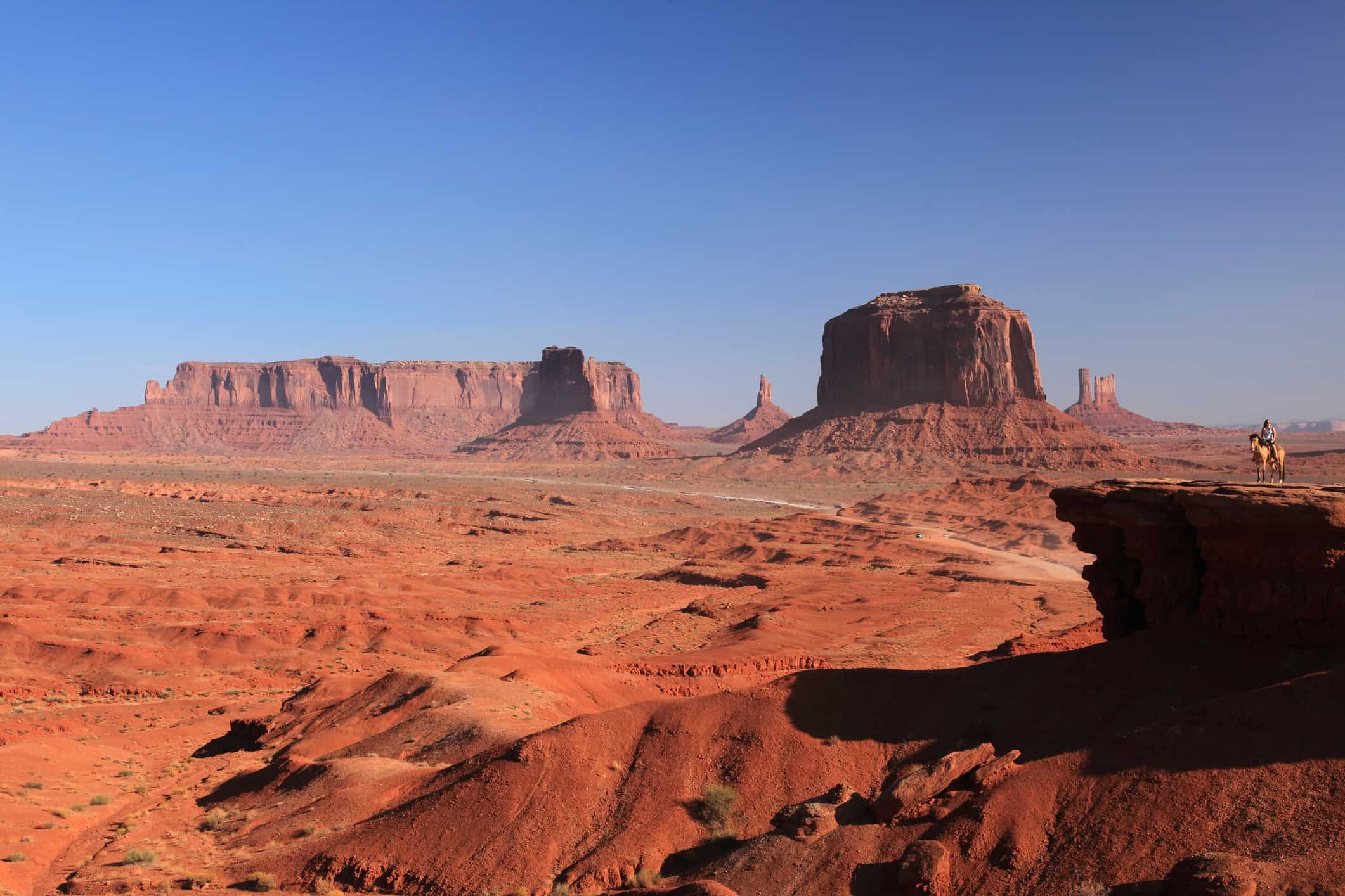 A woman riding on Horse from John Ford's Point overlook in Monument Valley Tribal Park in Arizona, USA