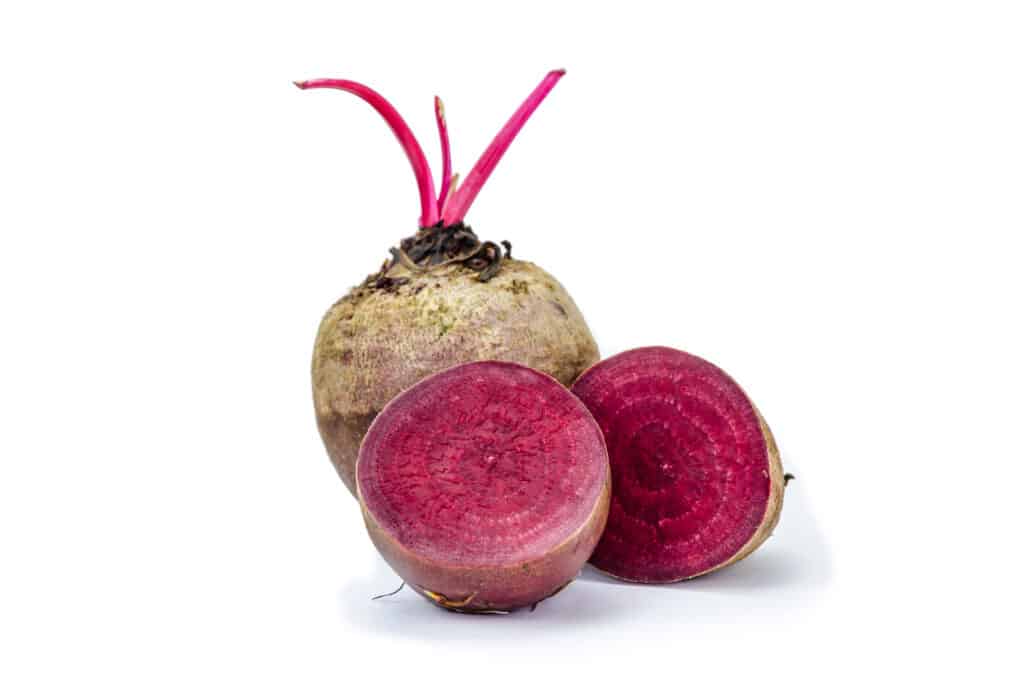 Nurtured by the earth's embrace: A robust beetroot, with its captivating purplish-red flesh, embodies both the earthy essence and nutritional vitality that lie beneath the soil's surface.