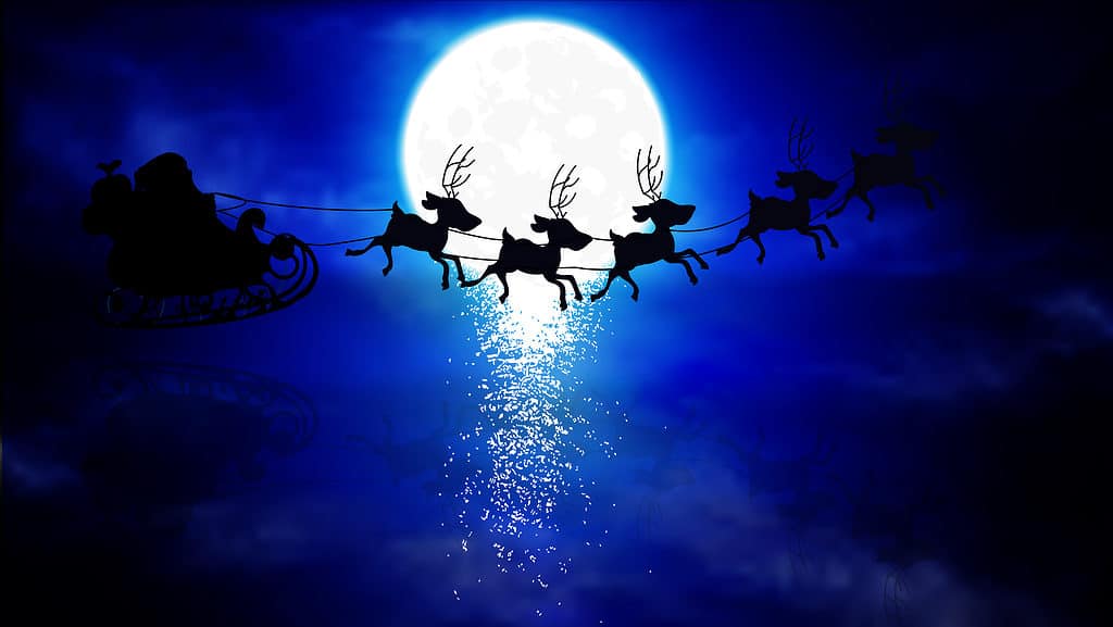 Santa and Reindeer Fly in Front of the Moon