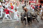 PAMPLONA, SPAIN -JULY 14: Unidentified men run from bulls in street Estafeta during San Fermin festival in Pamplona, Spain on July 14, 2013.
