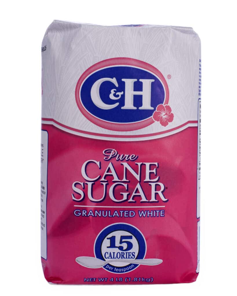 a 4 pound paper bag of sugar. The bag is white on the top quarter (1/4) with a blue (rimmed in pink) oval-shaped logo with white C&H. The bottom three quarters of the bag is pink with "CANE SUGAR" in all capital letters. against white isolate.