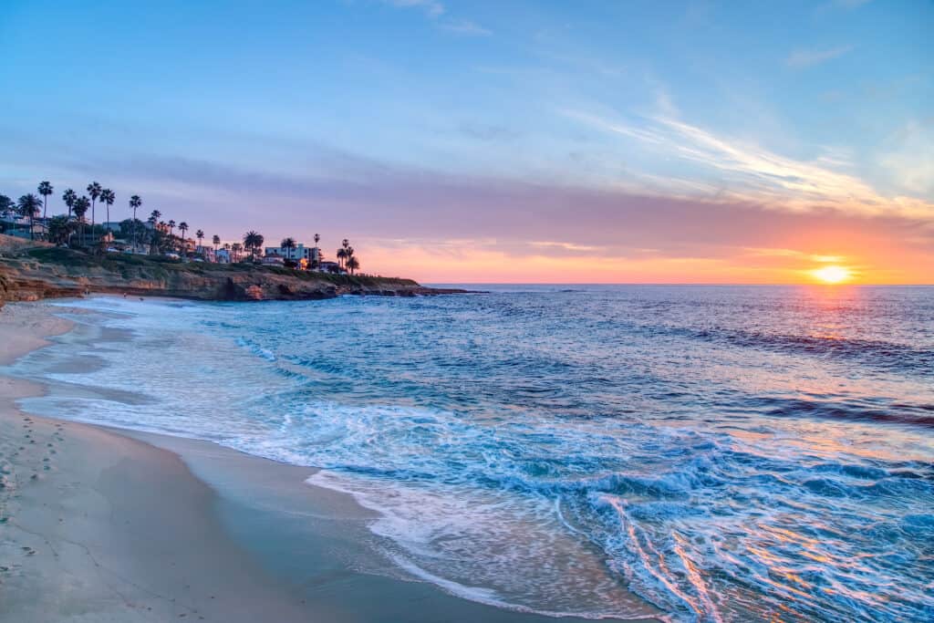 Clear blue water lapping on the shore at sunset