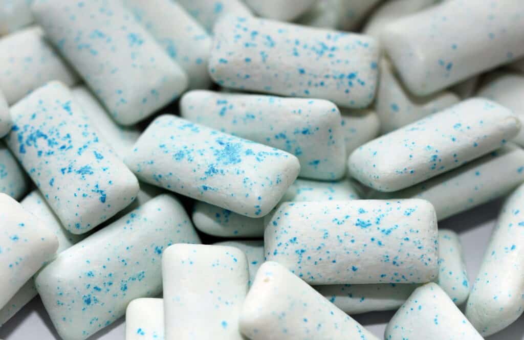 full frame several  rectangular-shaped pieces of white chewing gum flecked with blue.