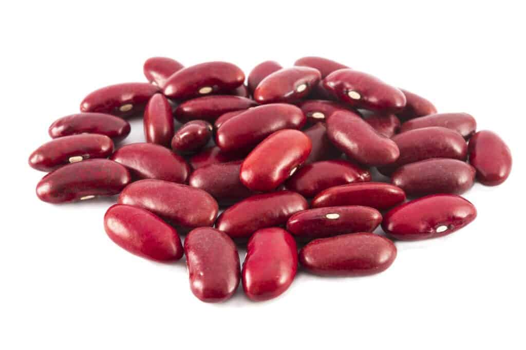 a mound of dark red kidney beans center frame on white background