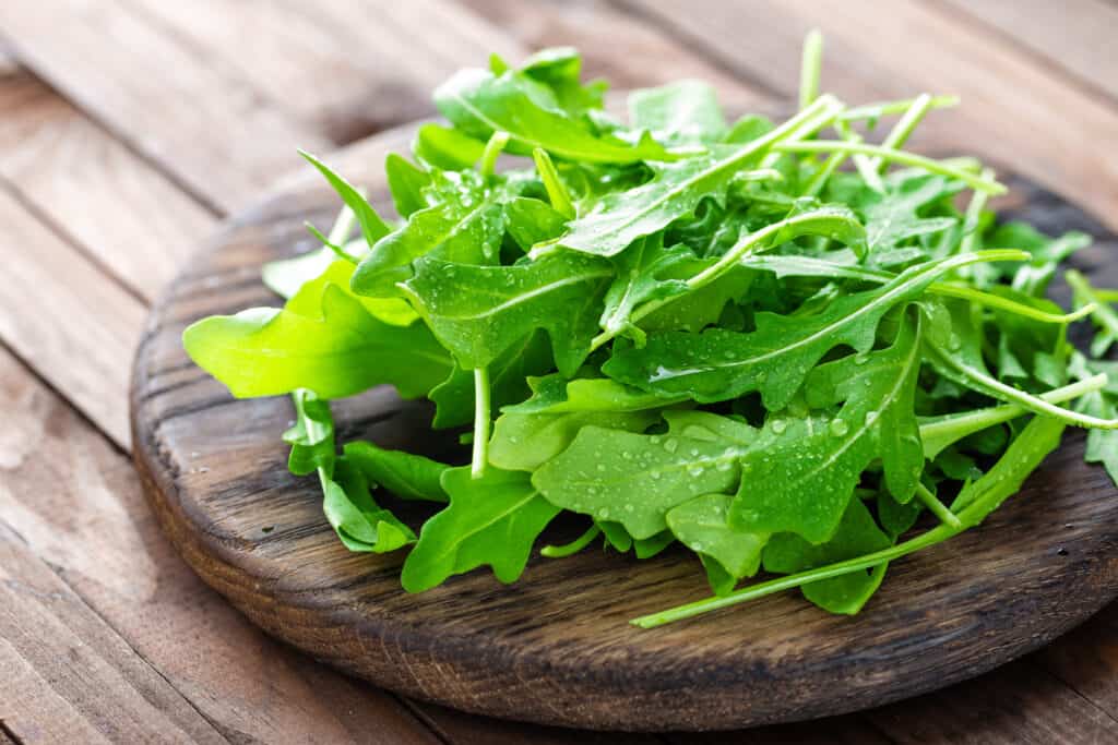 arugula on wooden plate