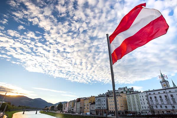 austrian flag over historic salzburg cityscape
