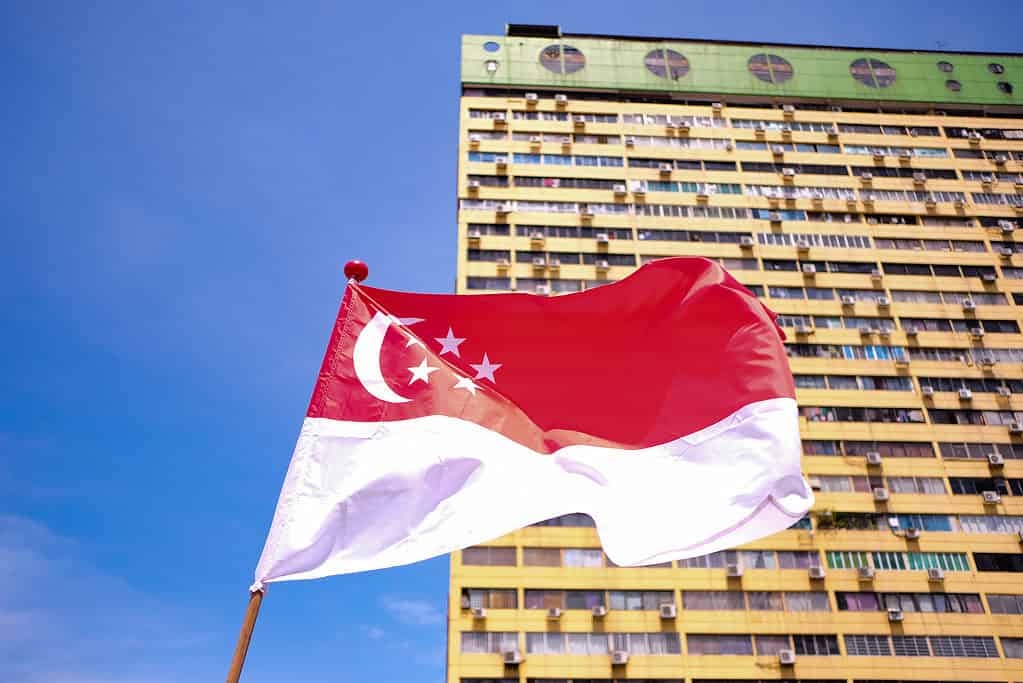 National flag of Singapore waving in the wind against the background of old buildings in People's Park