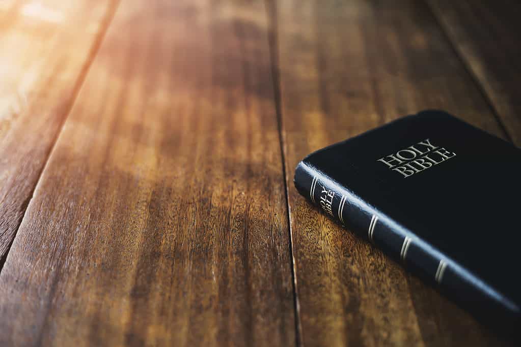 holy bible on the wooden table background with soft morning sunlight Christian background with copy space
