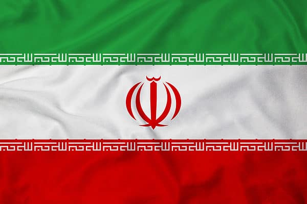 The flag of Iran is a tricolor with three evenly spaced bands of green, white, and red. In the center of the white band is the country's crest, which is red and stylized to look like a tulip.