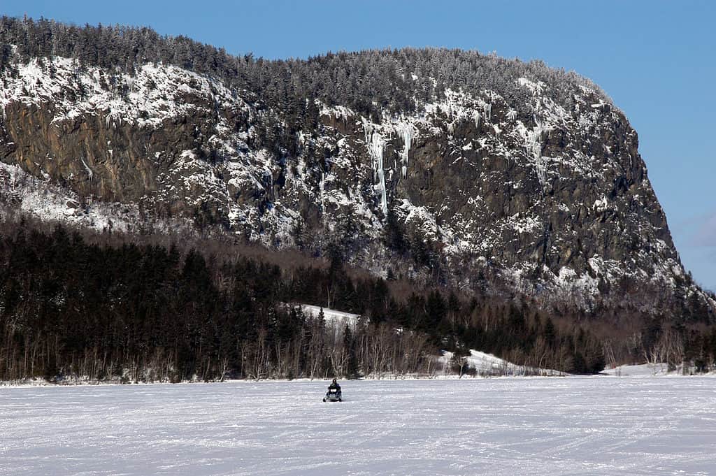 Snowmobiling on Moosehead Lake below Mount Kineo in Maine