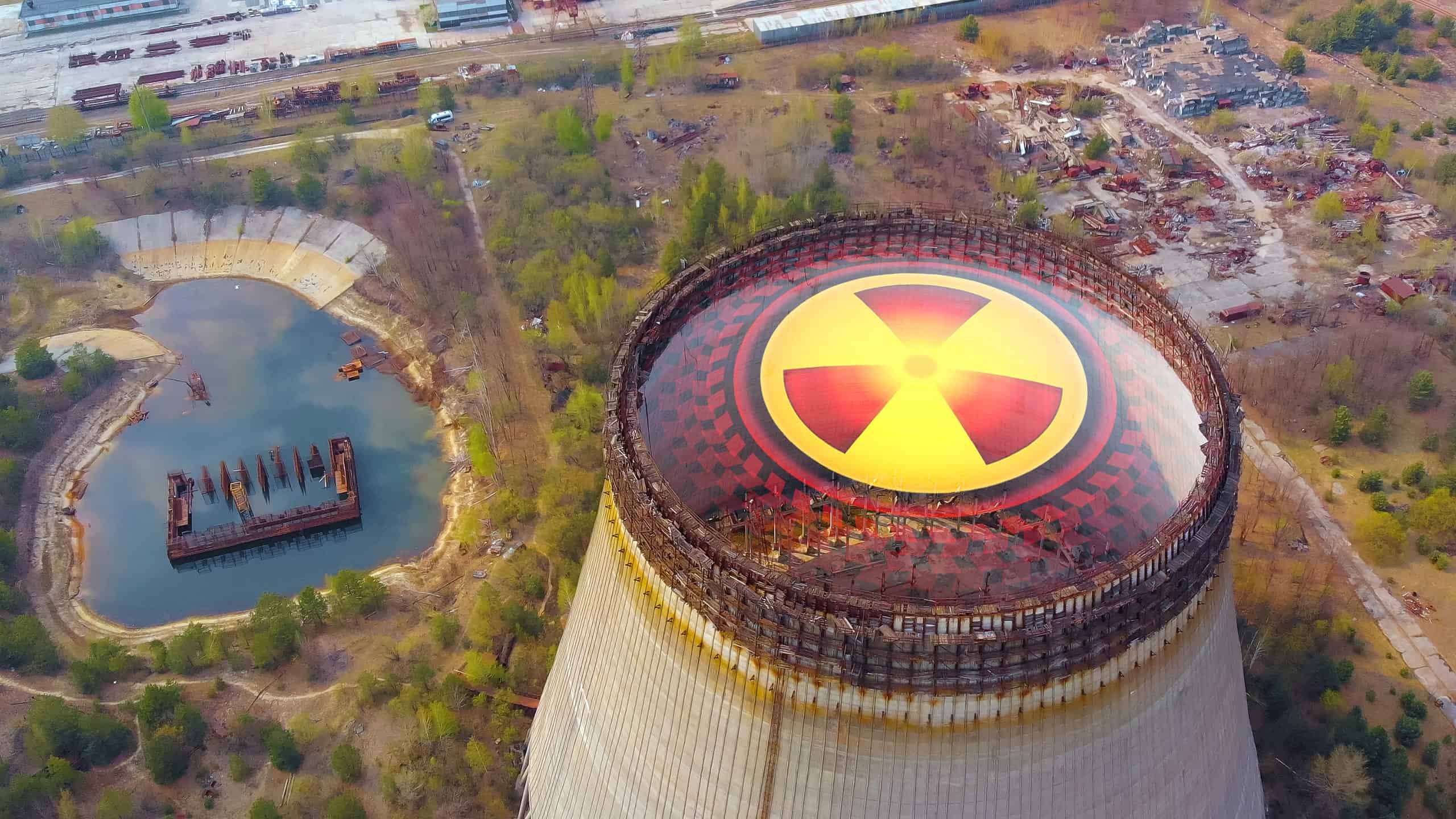 Chernobyl disaster. Radioactive zones near the reactor in Chernobyl. Sign of radiation on the background of the cooling tower in Chernobyl. Radiation contamination area near the Chernobyl reactor.