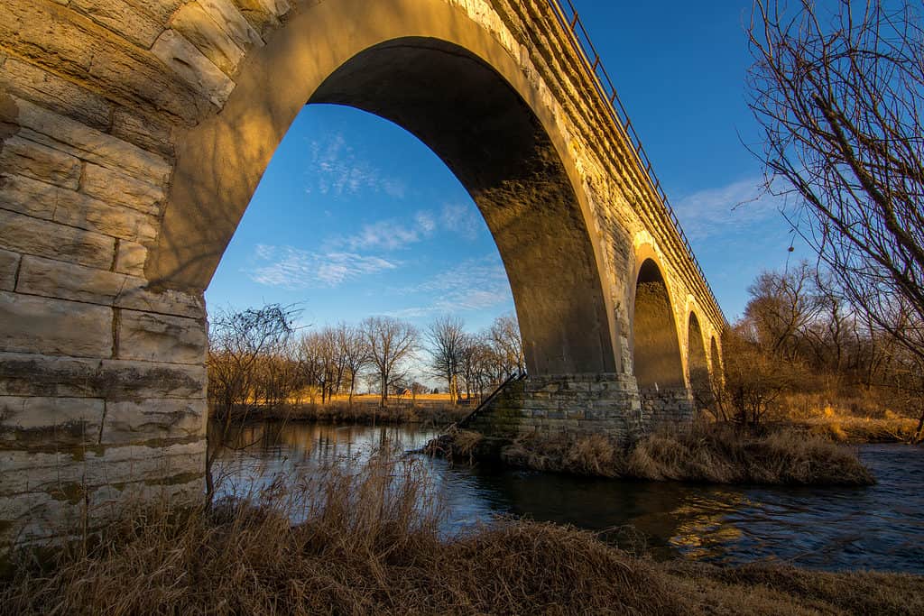 Photograph during golden hour of a historic five arch bridge across the Turtle Creek in southern Wisconsin. This is one of the best swimming holes in Wisconsin.