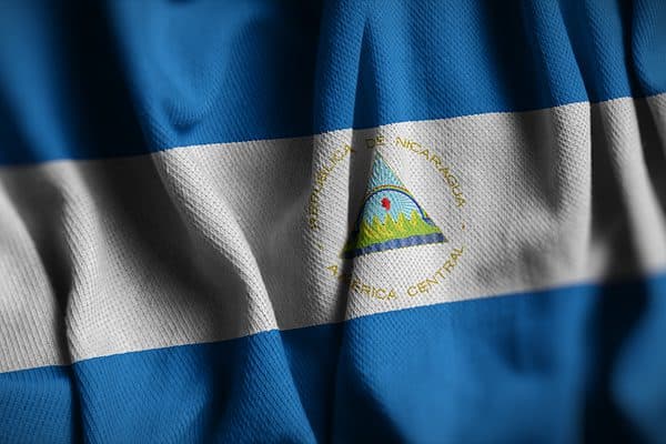 The Nicaraguan flag features a coat of arms depicting the country's landscape.