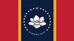 The flag of Mississippi consists of a white magnolia flower surrounded by 21 white stars and the words 'In God We Trust' written below, all put on a blue Canadian pale with two gold borders on a red field.