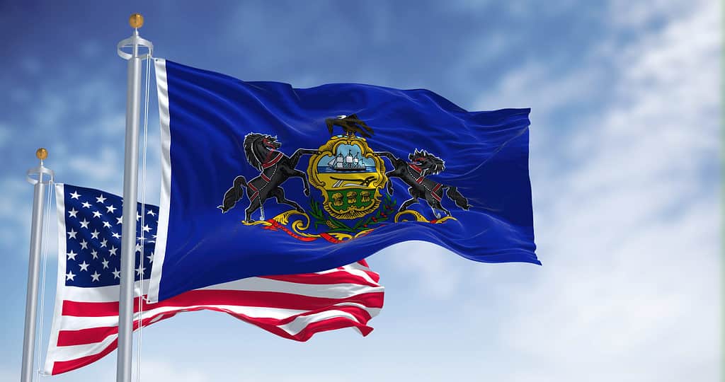 The Pennsylvania state flag waving along with the national flag of the United States of America