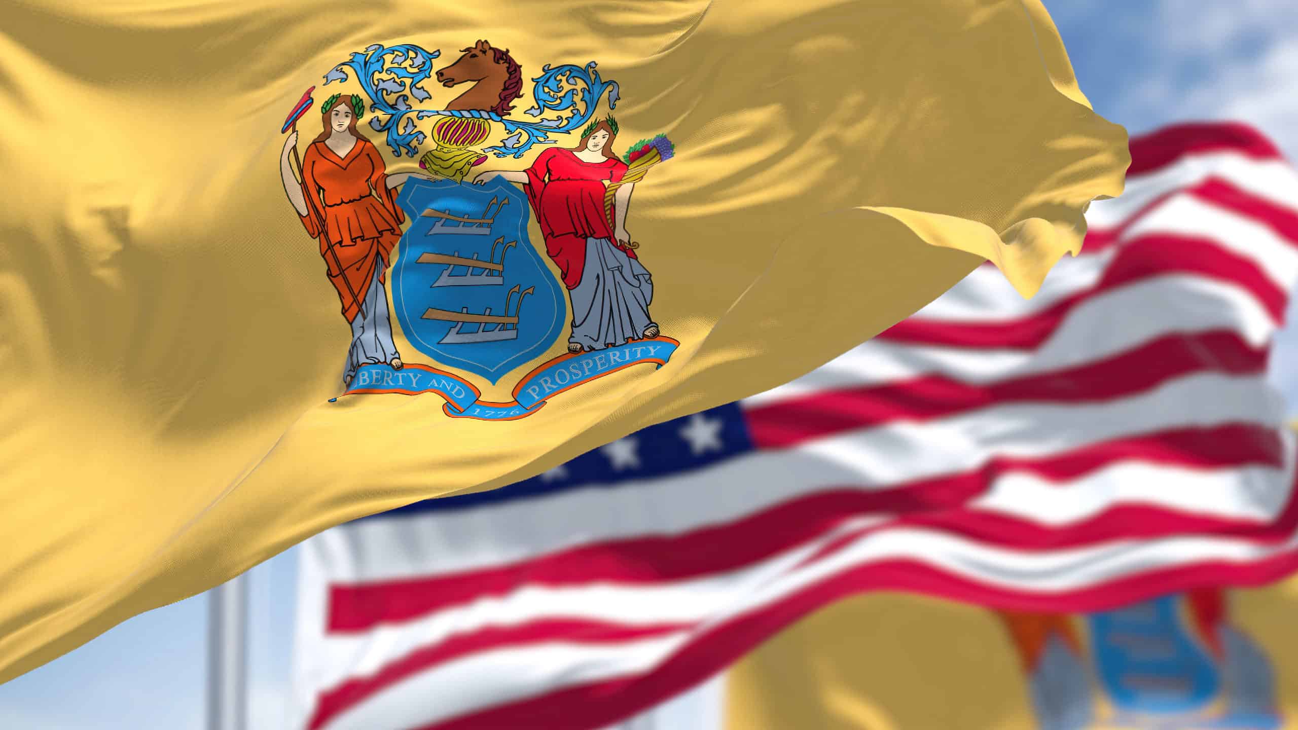 The New Jersey state flag waving along with the national flag of the United States of America