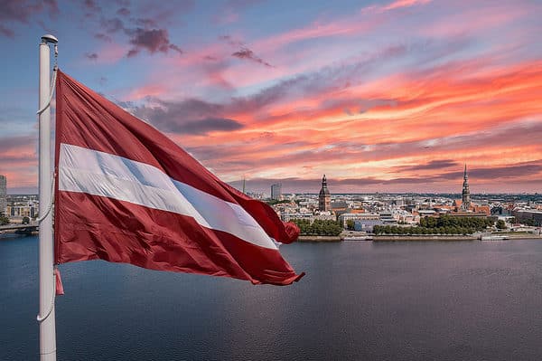 The flag of Latvia consists of crimson field (background) divided horizontally by a narrow white stripe. The flag's width-to-length ratio is 1 to 2.