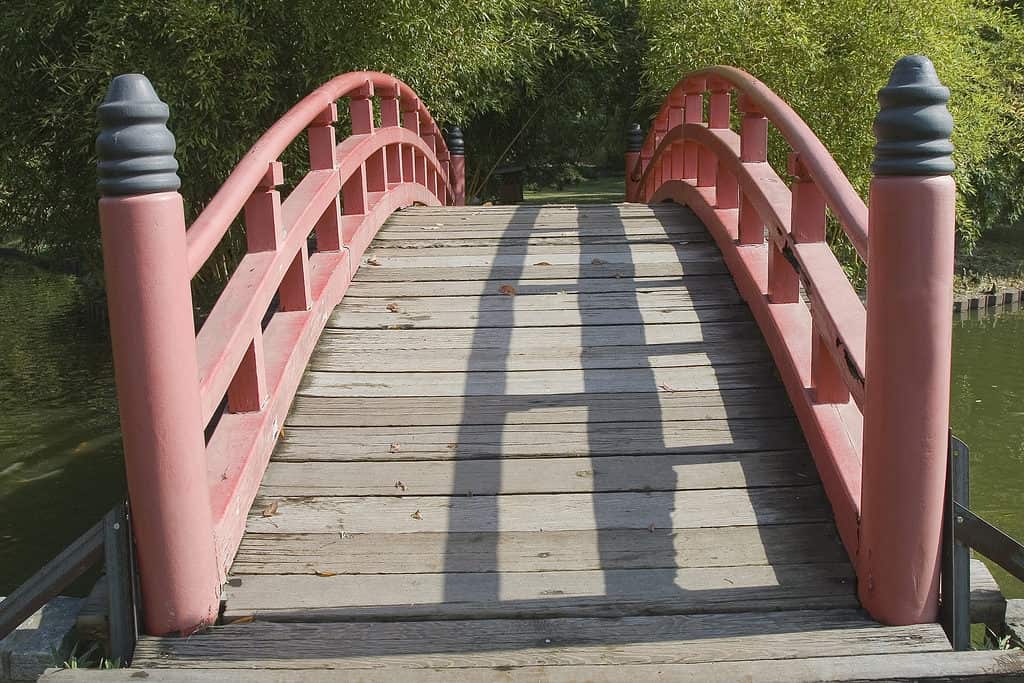 Red handrails on foot bridge in the Memphis Botanical Gardens in Tennessee.