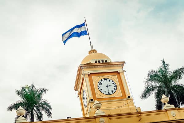 A small waving flag on the top of the City Hall of Santa Ana city, El Salvador.