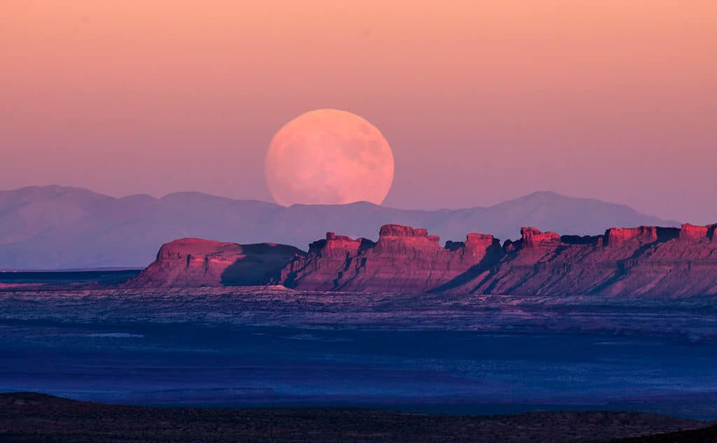Trăng tròn hoặc siêu trăng mọc trên Thung lũng Monument trên Vùng đất của Bộ lạc Navajo ở biên giới Utah/Arizona.
