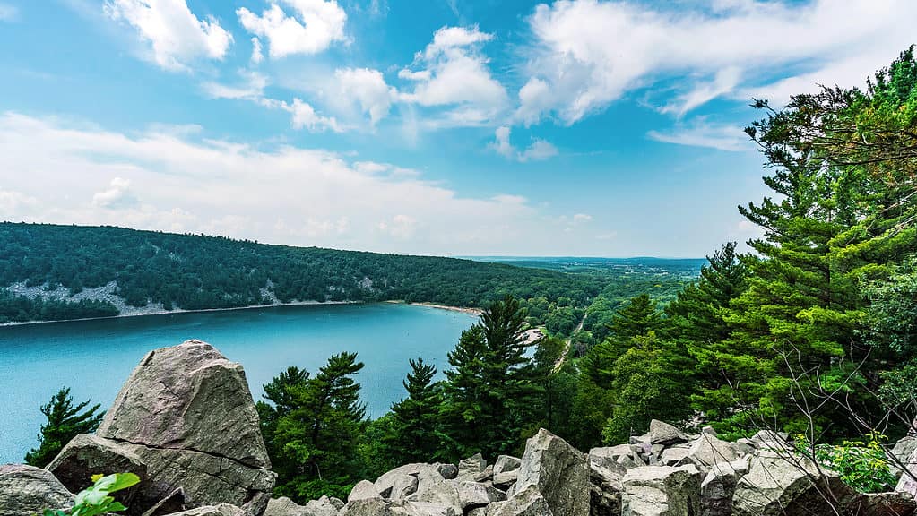 East Bluff trail in Devil's Lake State Park near Baraboo, Wisconsin, USA overlooking the majestic view of the serene body of water and rolling hills in the Midwest.