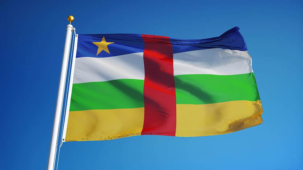 The flag of the Central African Republic flying against a cloudless blue sky