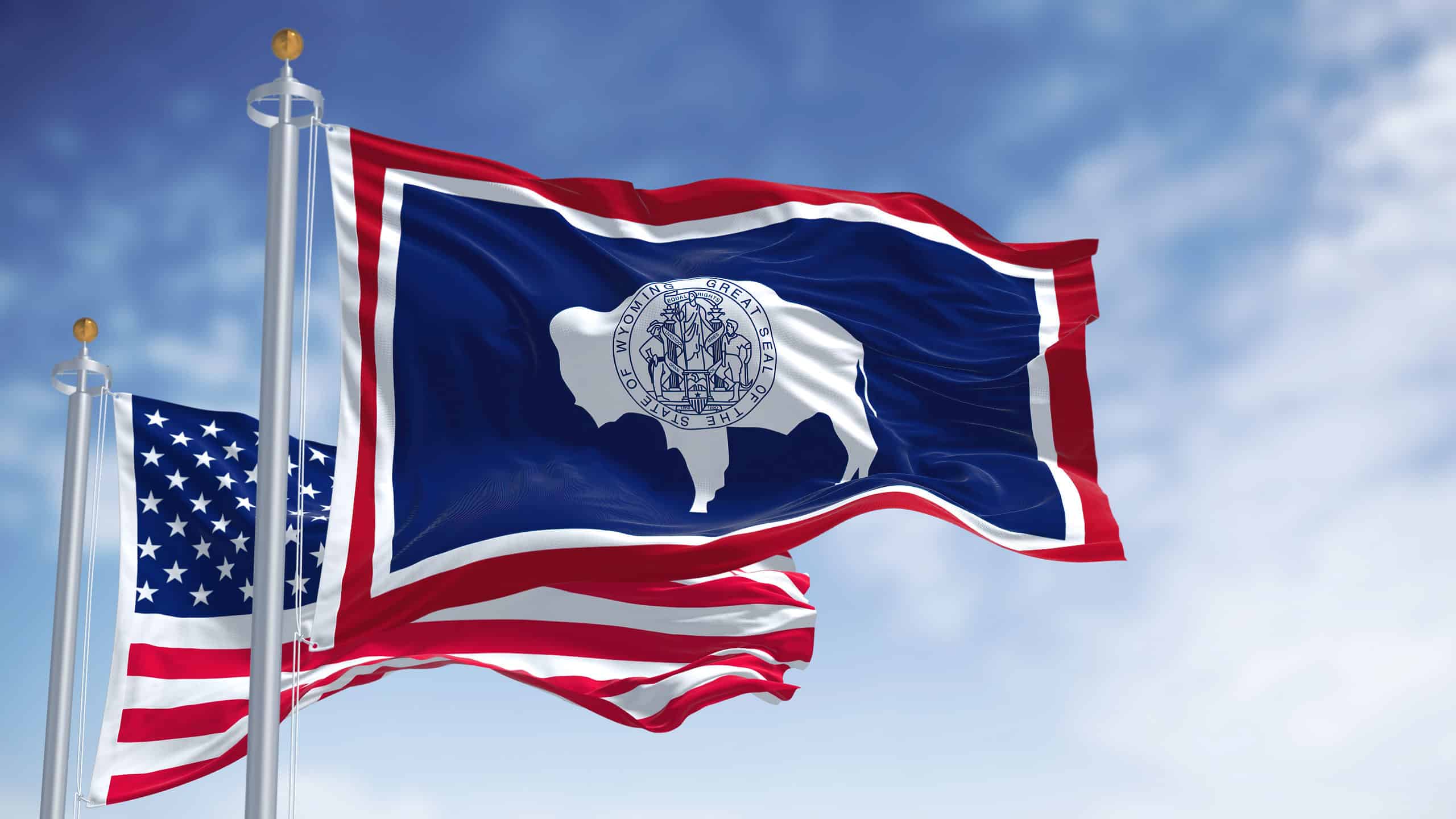 Wyoming state flag with the American flag flying behind it