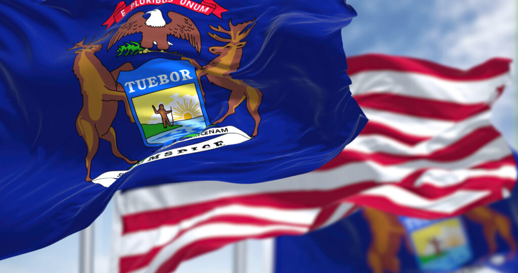 Close-up view of the Michigan flag with the United States flag in the background