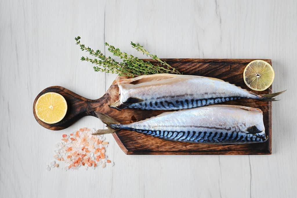 Overhead view of headless mackerel on cutting board