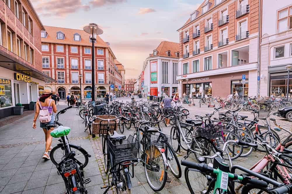 25 July 2022, Munster, Germany: Many bicycles and bikes parked at public parking lot at city street. Muenster considered a bicycle capital of Germany