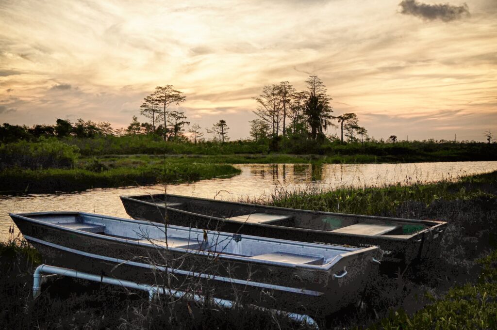 Silhouettes of tin boats sit on the shore of the Everglades in South Florida