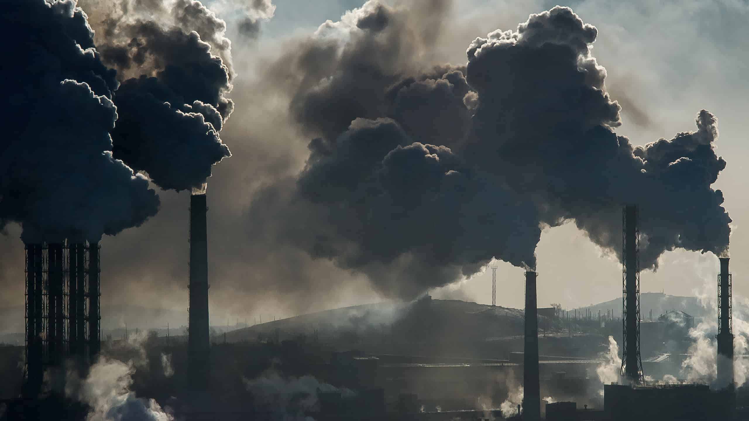 A black cloud of pollution emits from a factory