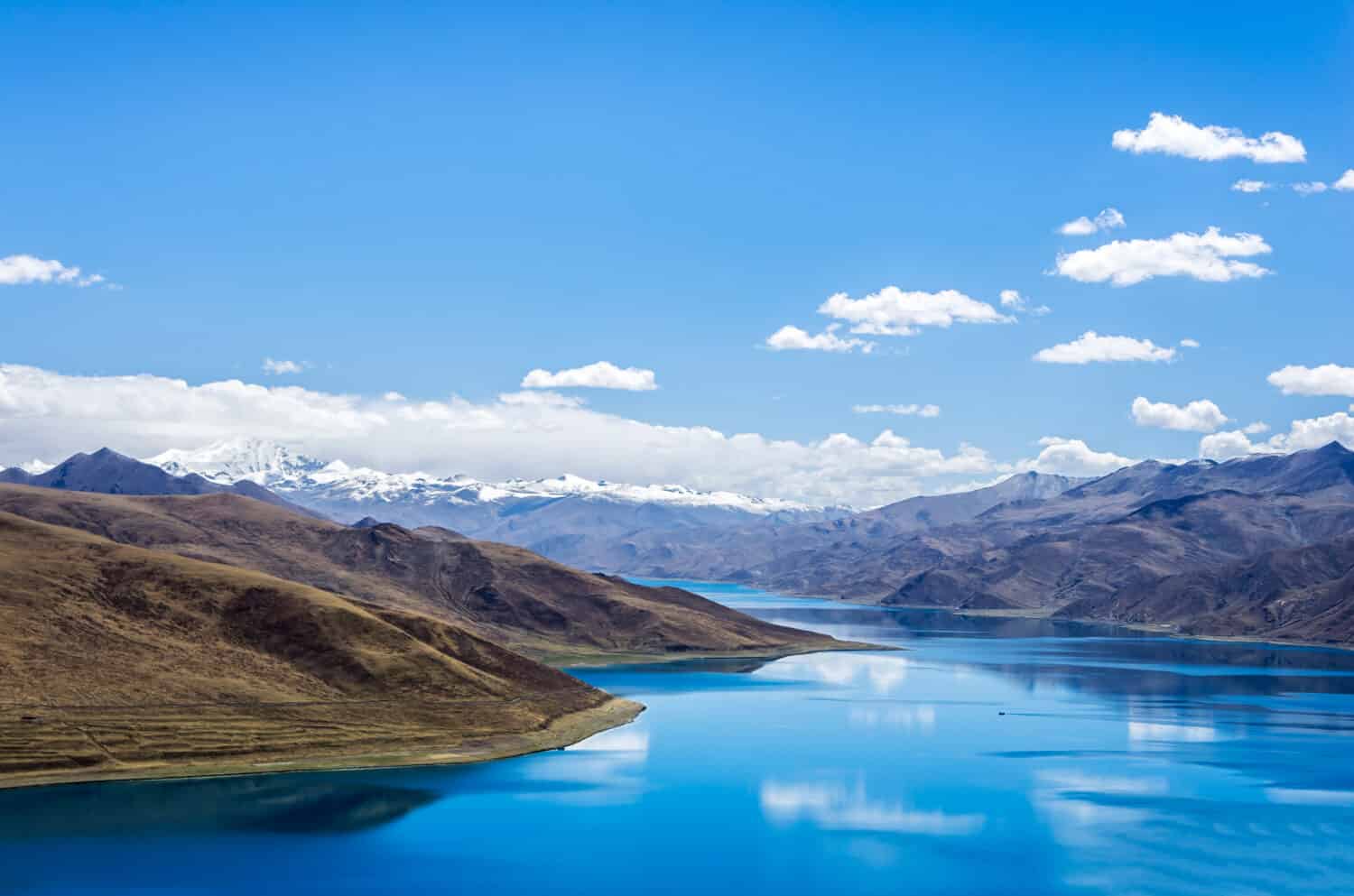Yamdrok lake"the fifth largest lake in the Tibet,China.beautifual blue lake on Highest land with mountains under blue sky and white clouds.Landmark of Tibet.